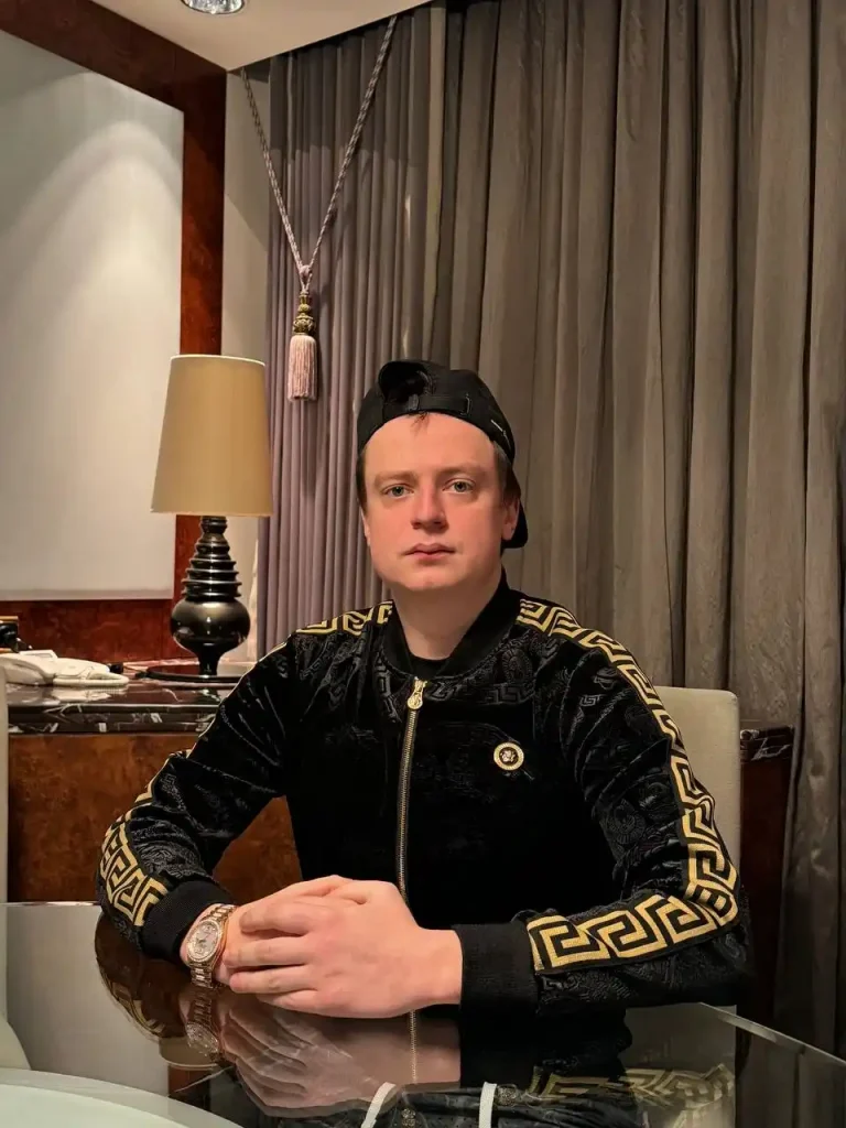 Mellstroy sitting at a luxury dinner table in a black shirt